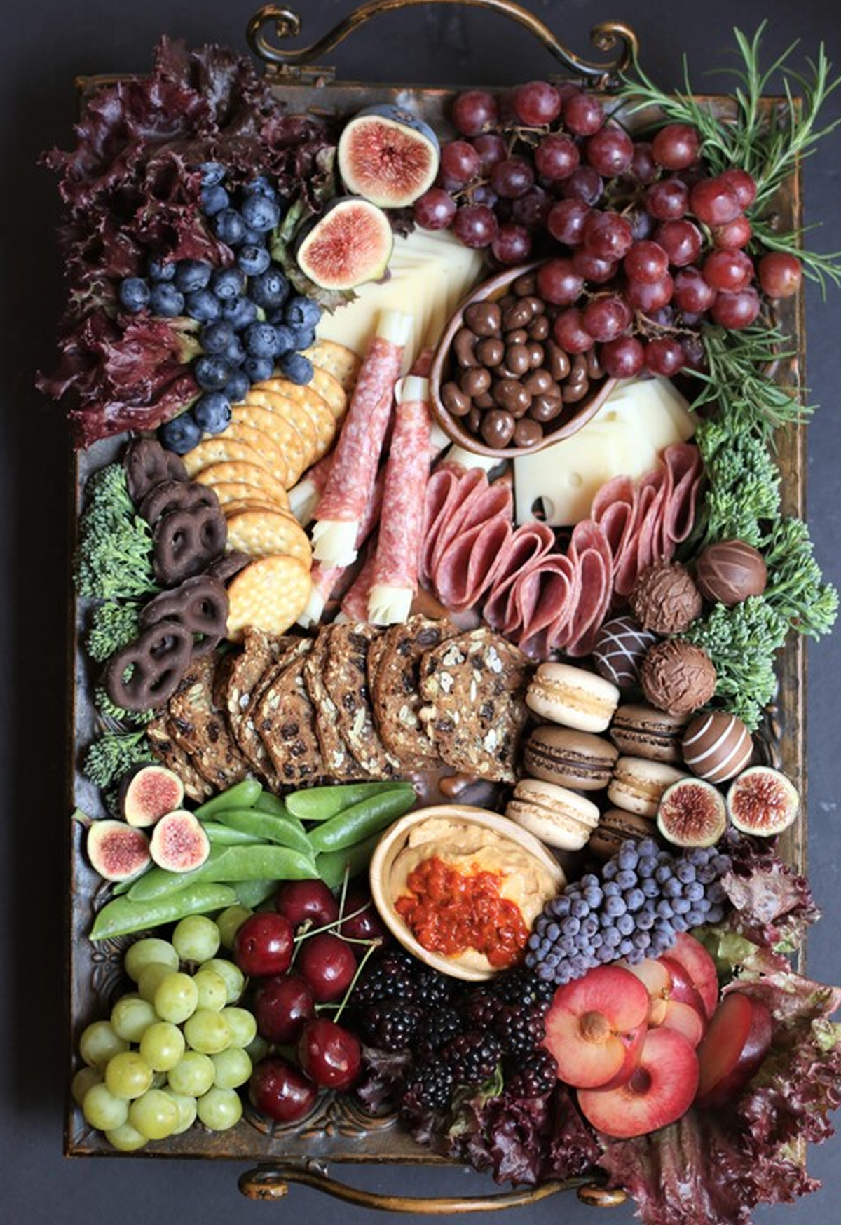 a mature picnic charcuterie board with meat, chocolates, grapes, blueberries, cheese and more from snowflakes and coffeecakes.