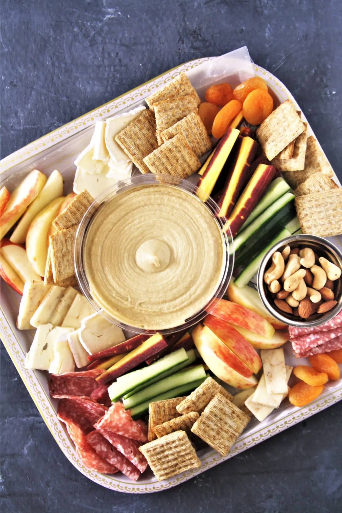 a board with veggies, fruits, hummus, crackers, cheese, etc from the tasty bite blog.