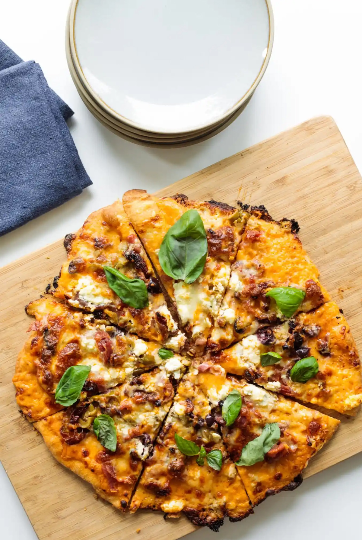 Cured meats, olives, and cheese fill the pizza on The Reluctant Entertainers pizza charcuterie board.