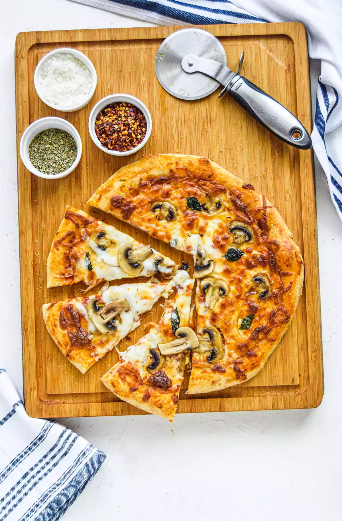 Simply Recipes pizza board showcases a homemade mushroom and cheese pizza with different toppings.