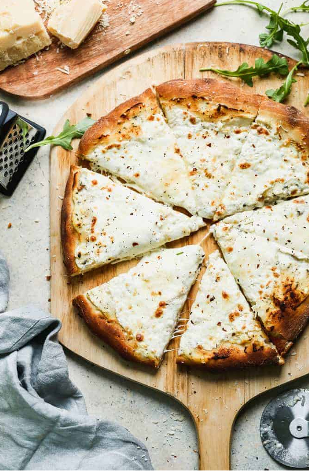 A white pizza with lots of cheese fills Tastes Better From Scratch pizza board.