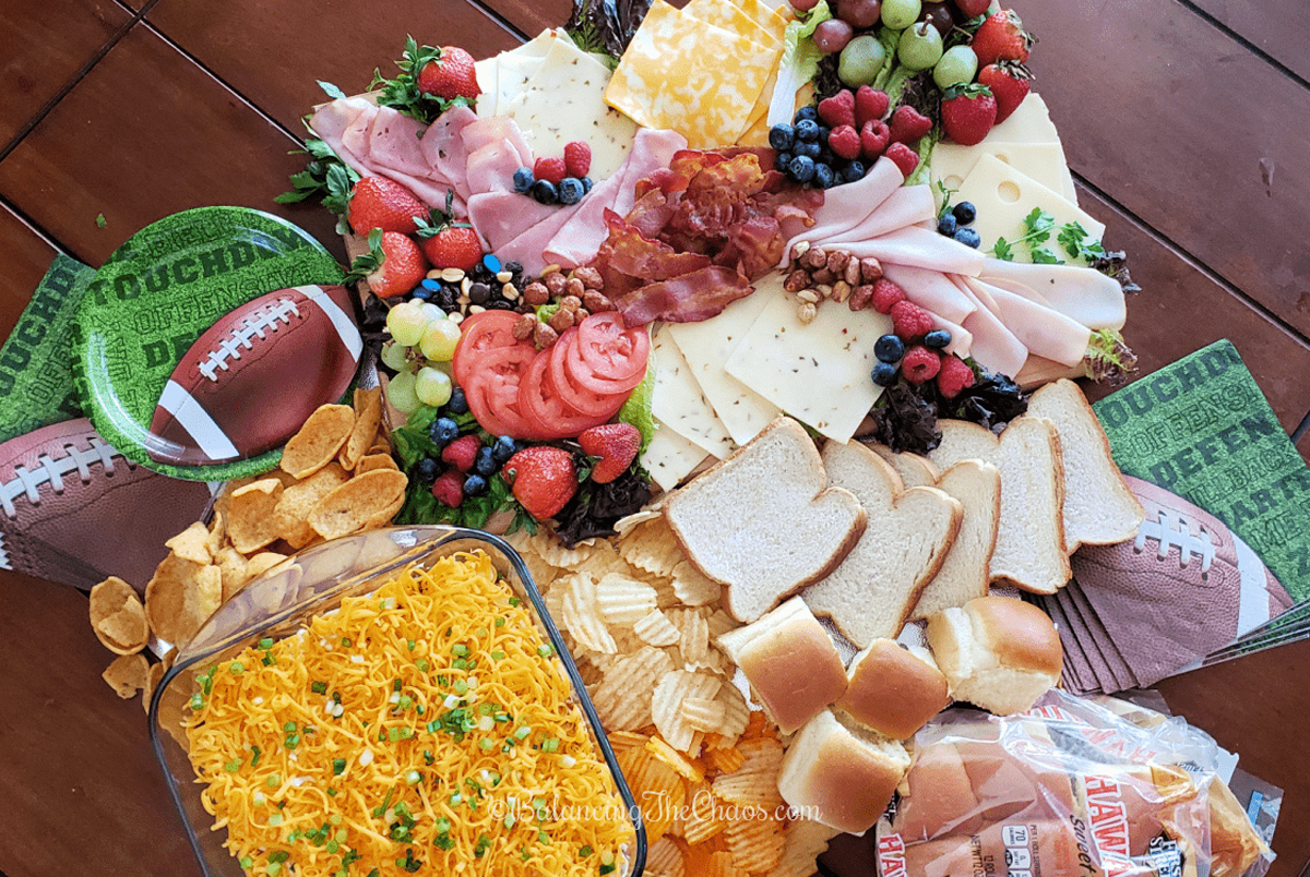 Deli meat, cheese, tomatoes, fruit, chips, chili dip and bread fill Balancing the Chaos sandwich board.