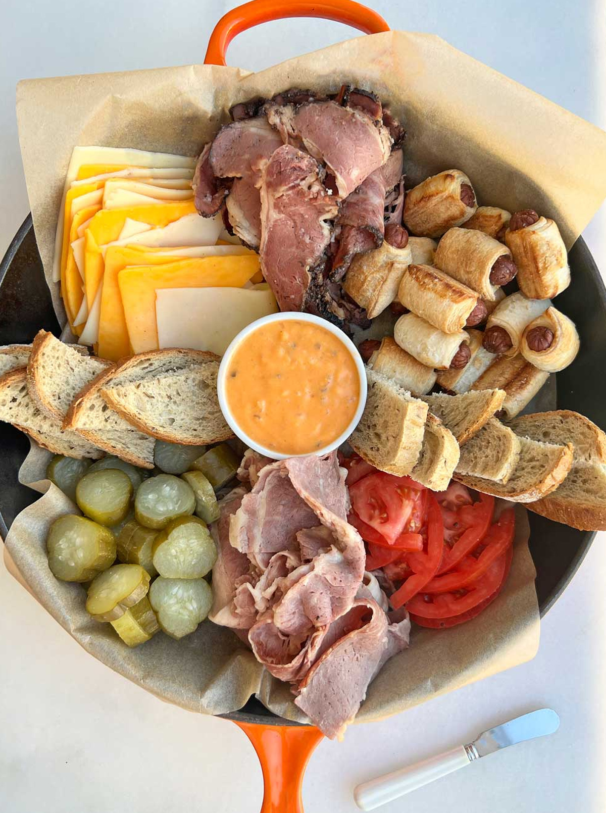 Swiss, cheddar, deli meats, thousand island dressing, and pigs in a blanket are on Chop Happy's Sandwich Charcuterie Board.