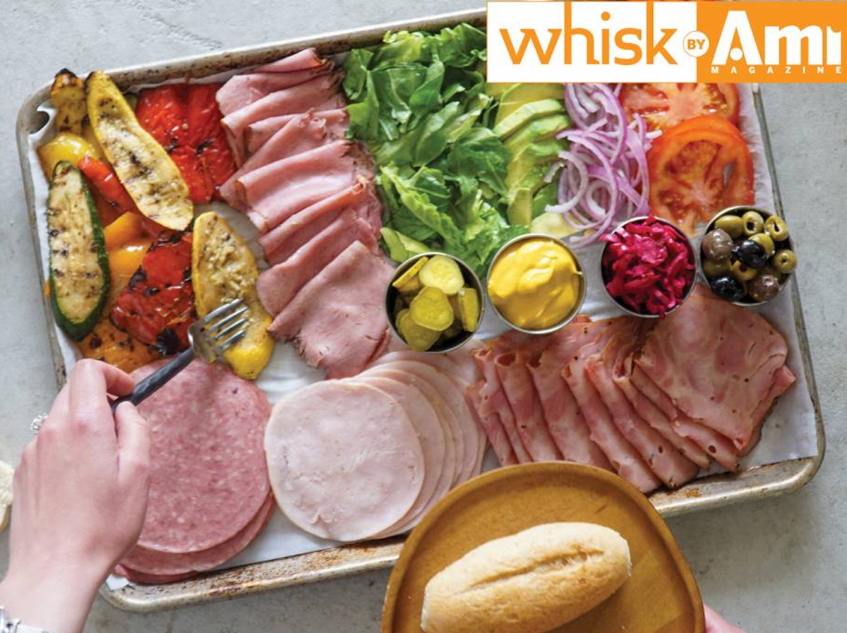 Kosher deli meats, cheeses, condiments, veggies, bread, and condiments fill Kosher.com's deli sandwich board.