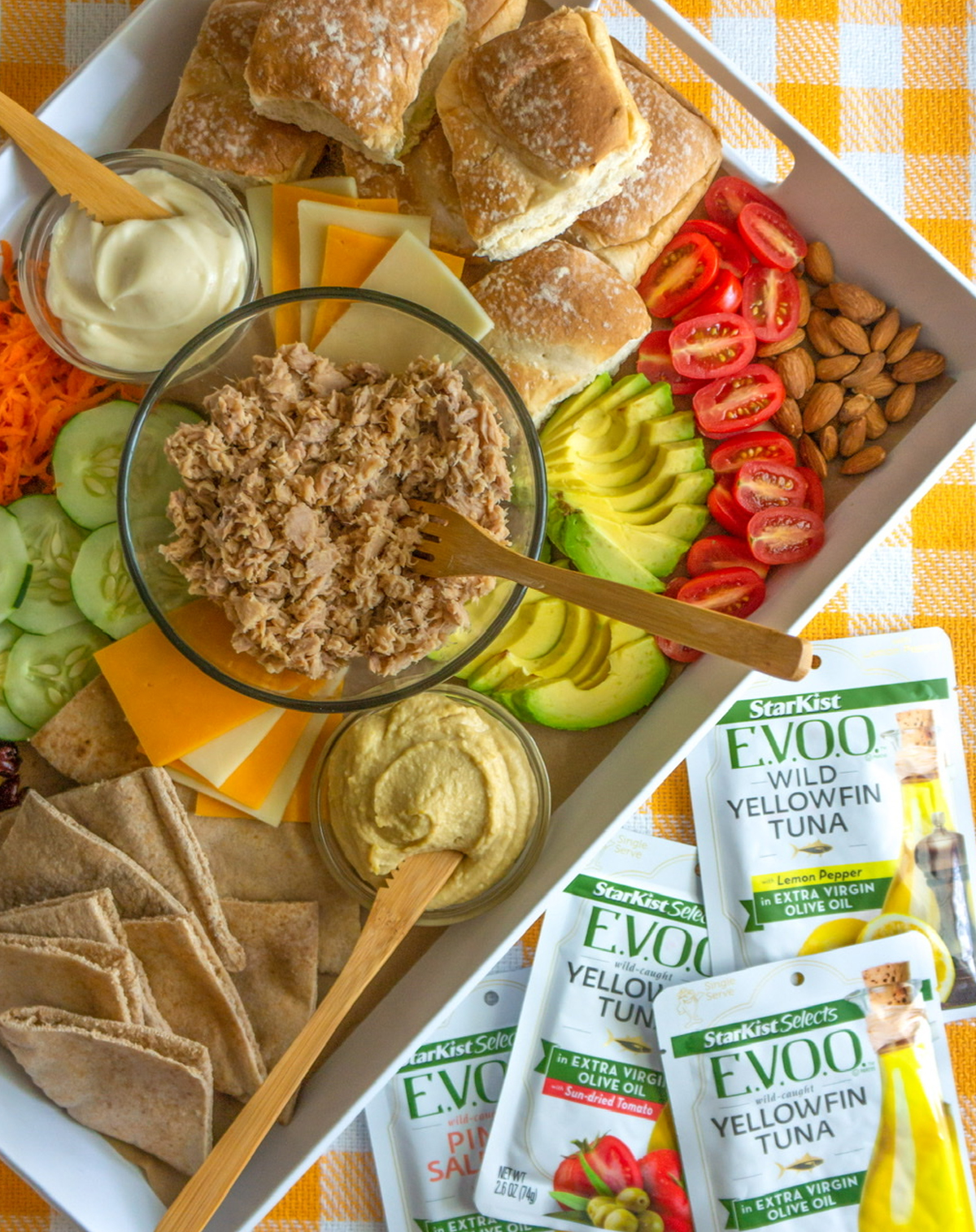 The Cinnamon Mom's tuna sandwich board includes, avocados, cucumbers, tomatoes, nuts, mayo, and bread.