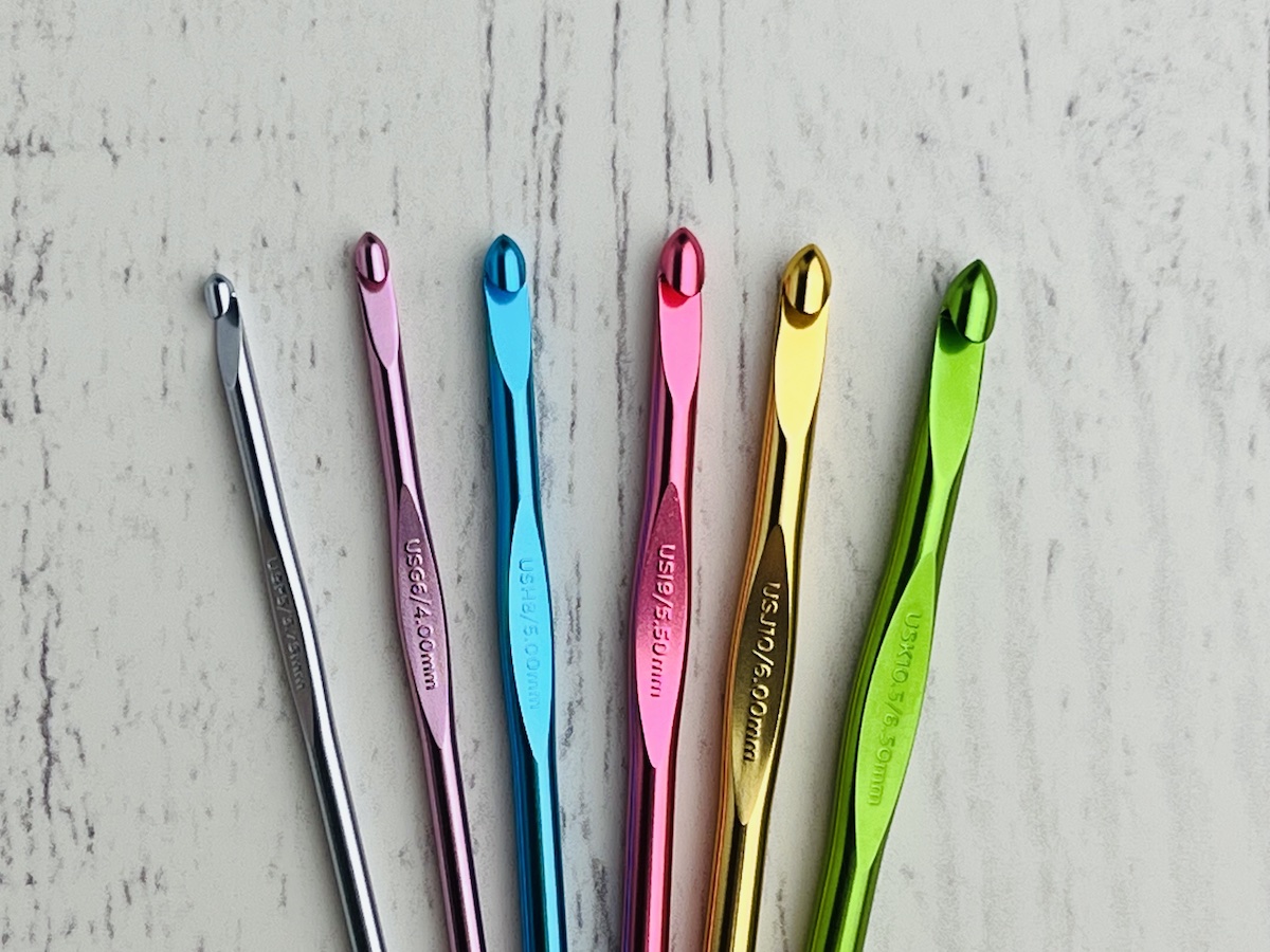 crochet hooks of different sizes and colors on a white background