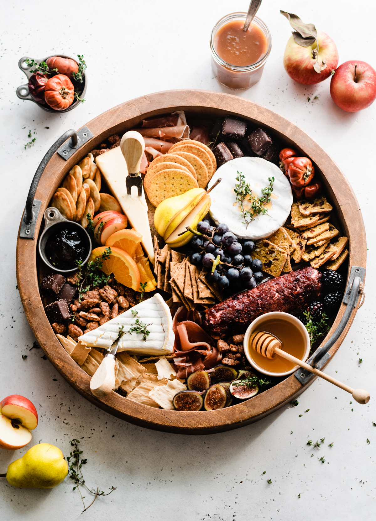 Soft cheese, festive fruits, crackers, and meats fill Blue Bowl Recipes' fall cheese board.
