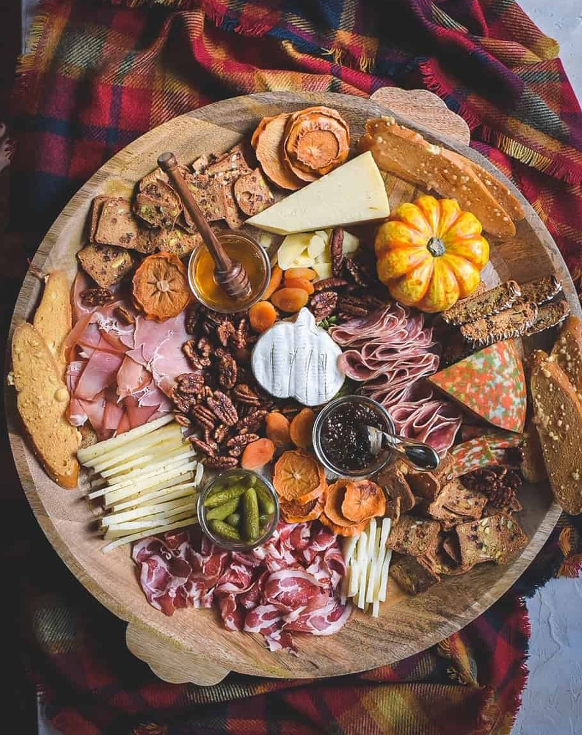 Cafe Sazon y Vida's charcuterie board  showcases pumpkin shaped brie, dried fruit, meats, and cheese.