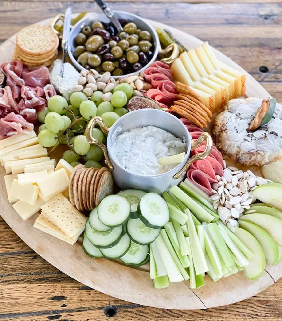 The Food Talk Daily's fall board includes meats, crackers, cheese, dips, olives, and grapes.