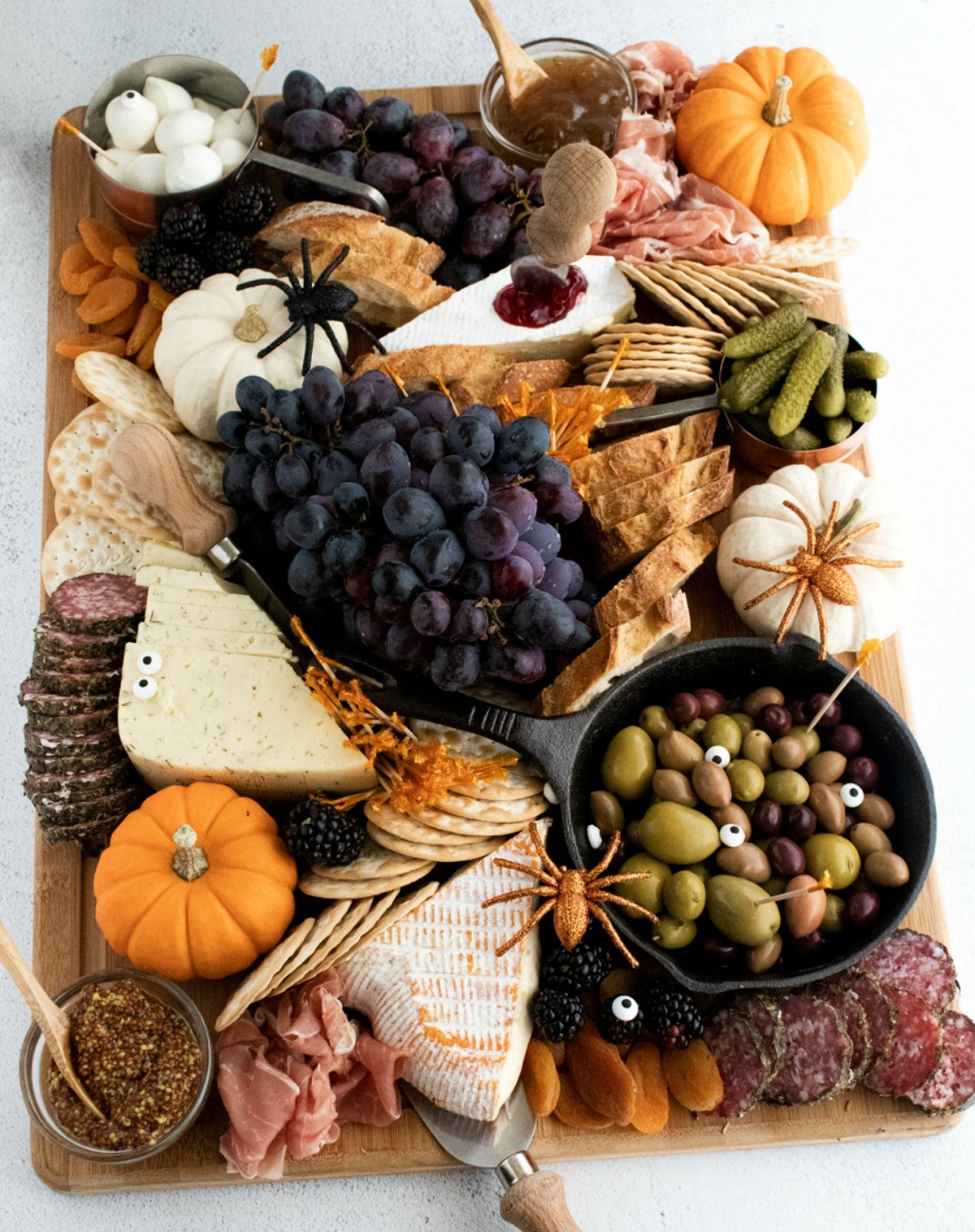 Happily Unprocessed's fall board is full of crackers, cheeses, meats, grapes, and olives.