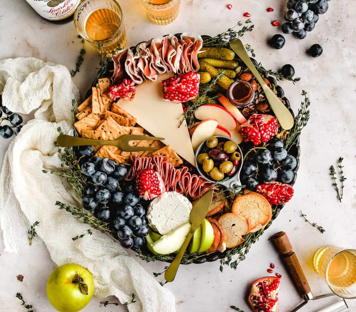 Healthy Little Peach's fall board displays grapes, pomegranate, olives, chesses, meats, and crackers.
