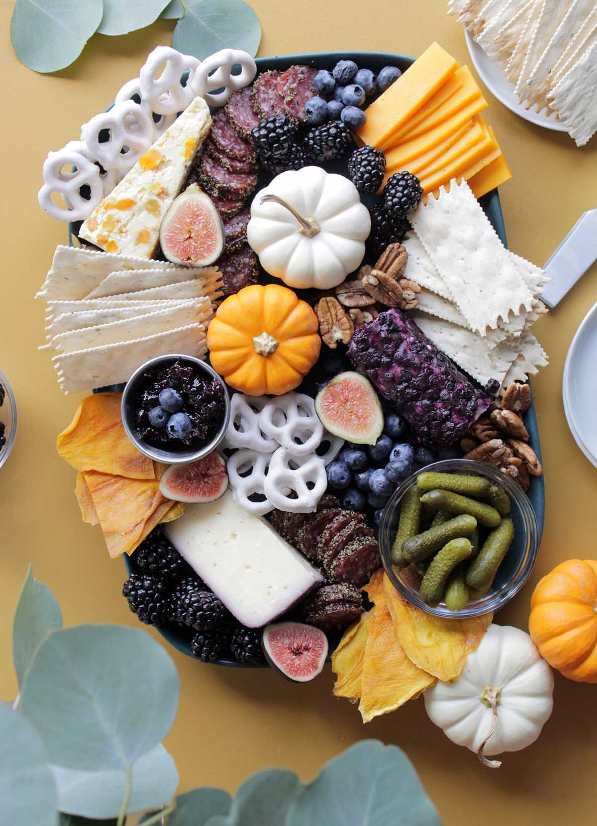 Homebody Eats' fall board has cheese, crackers, berries, meats, pretzels, and pickles.