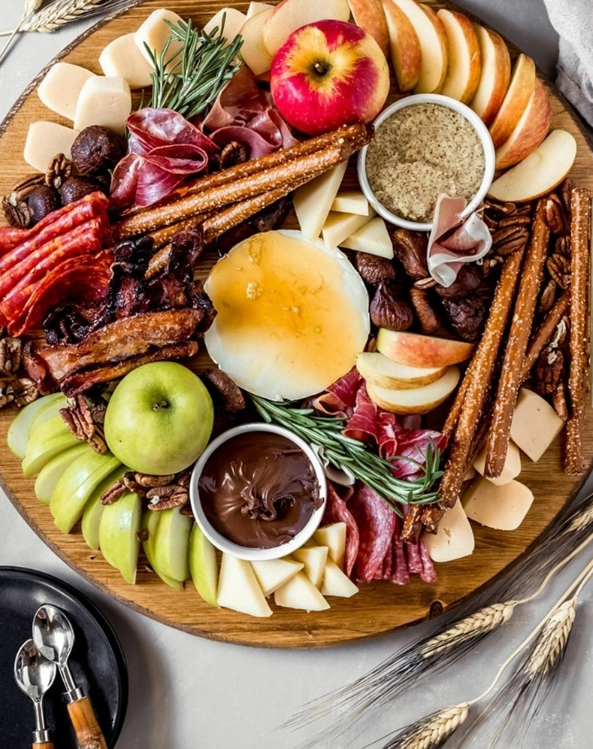 Wanderlusr and Wellness' includes honey-covered brie, apple slices, prunes, pretzel sticks, and candied bacon on their autumn themed charcuterie board.