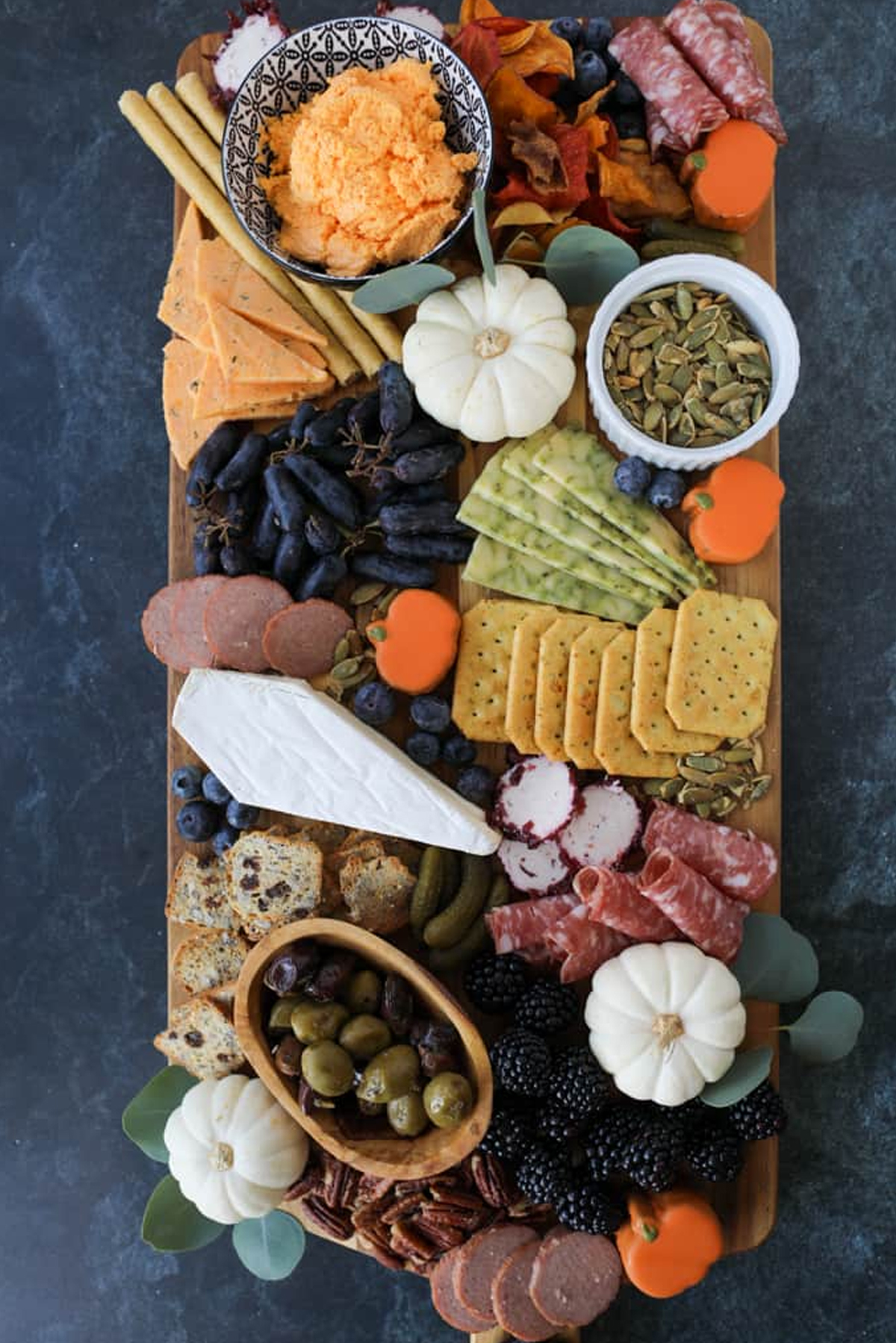 A Whole Lotta Yum showcases pumpkin iced cookies, cheese, berries, meat, grapes, and olives.