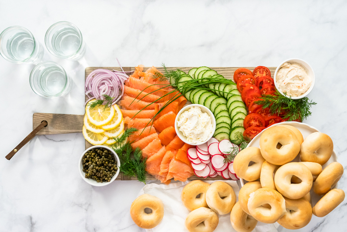 arina photography bagel charcuterie board with salmon, veggies, and bagels.