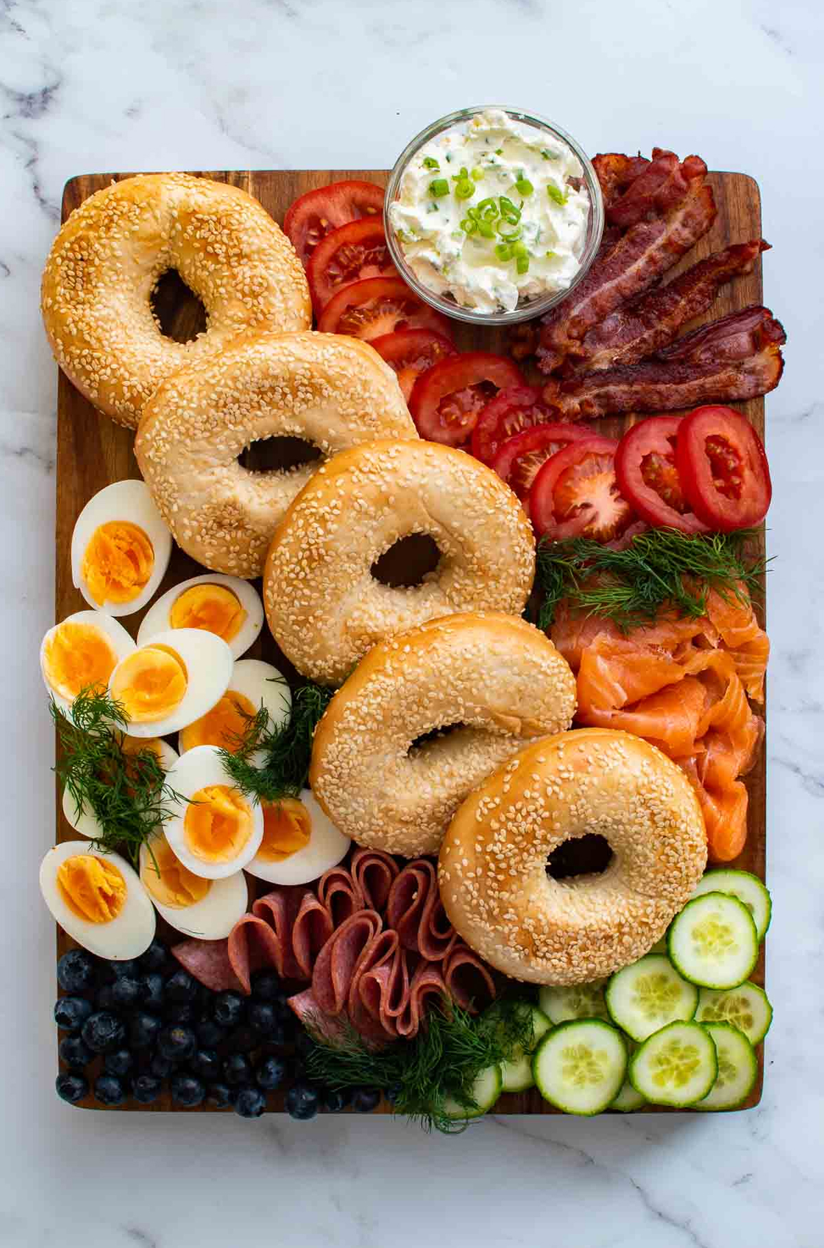 hard boiled eggs, tomatoes, cream cheese, lox, and bacon cover this bagel board from hint of healthy.
