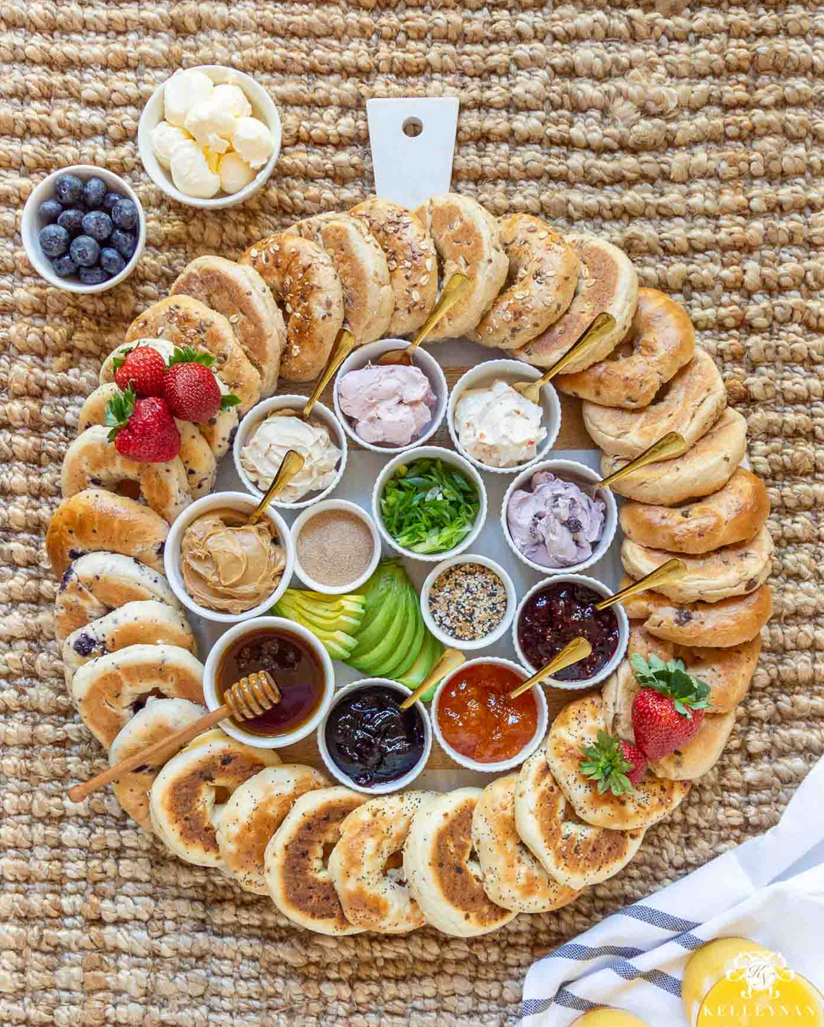 a round board with bagels around the outer edge and toppings covering the middle from kelleynan.