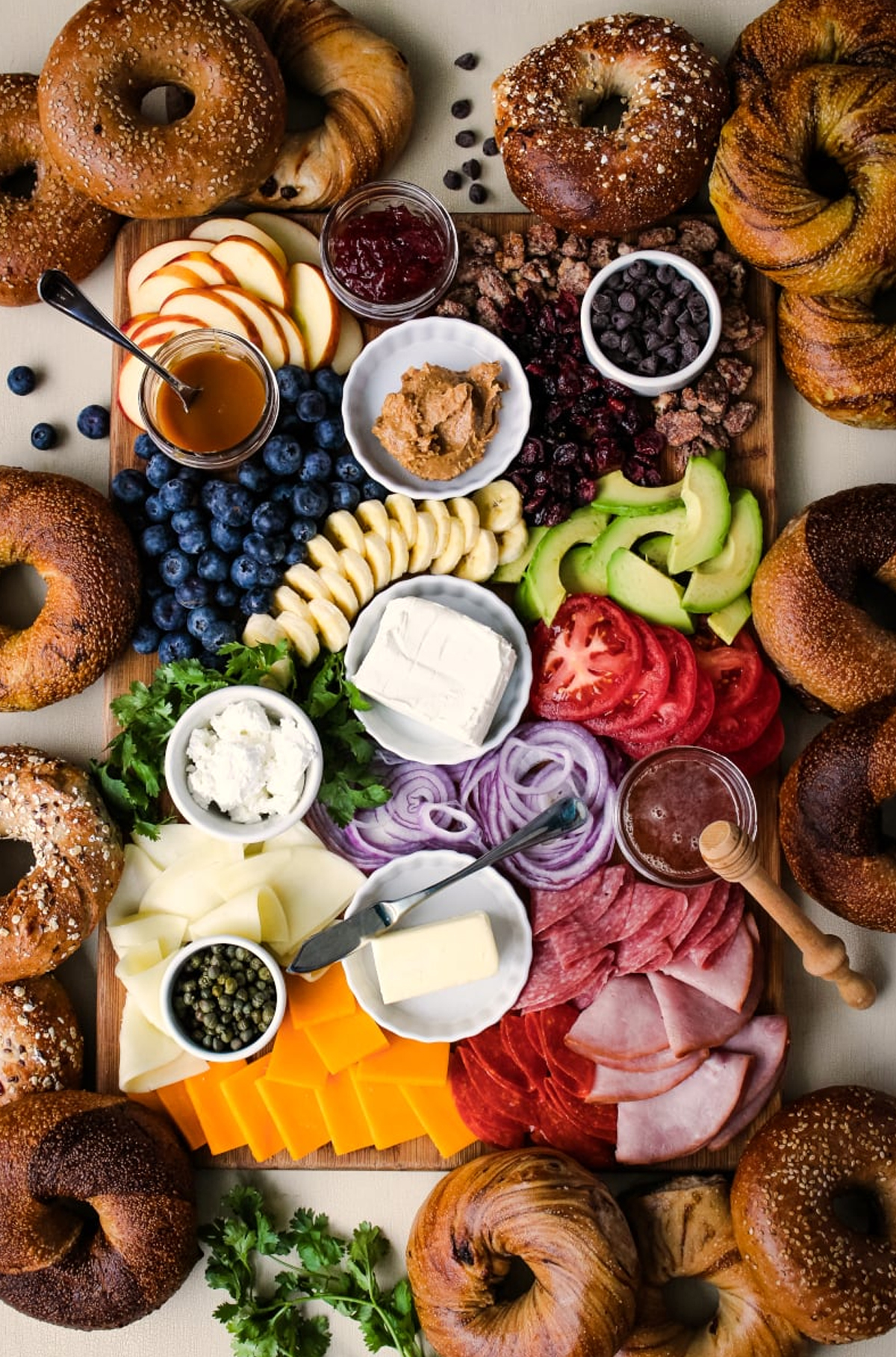 the two bite club bagel board with toppings like peanut butter, cream cheese, apple slices, honey, chocolate chips ,and more.