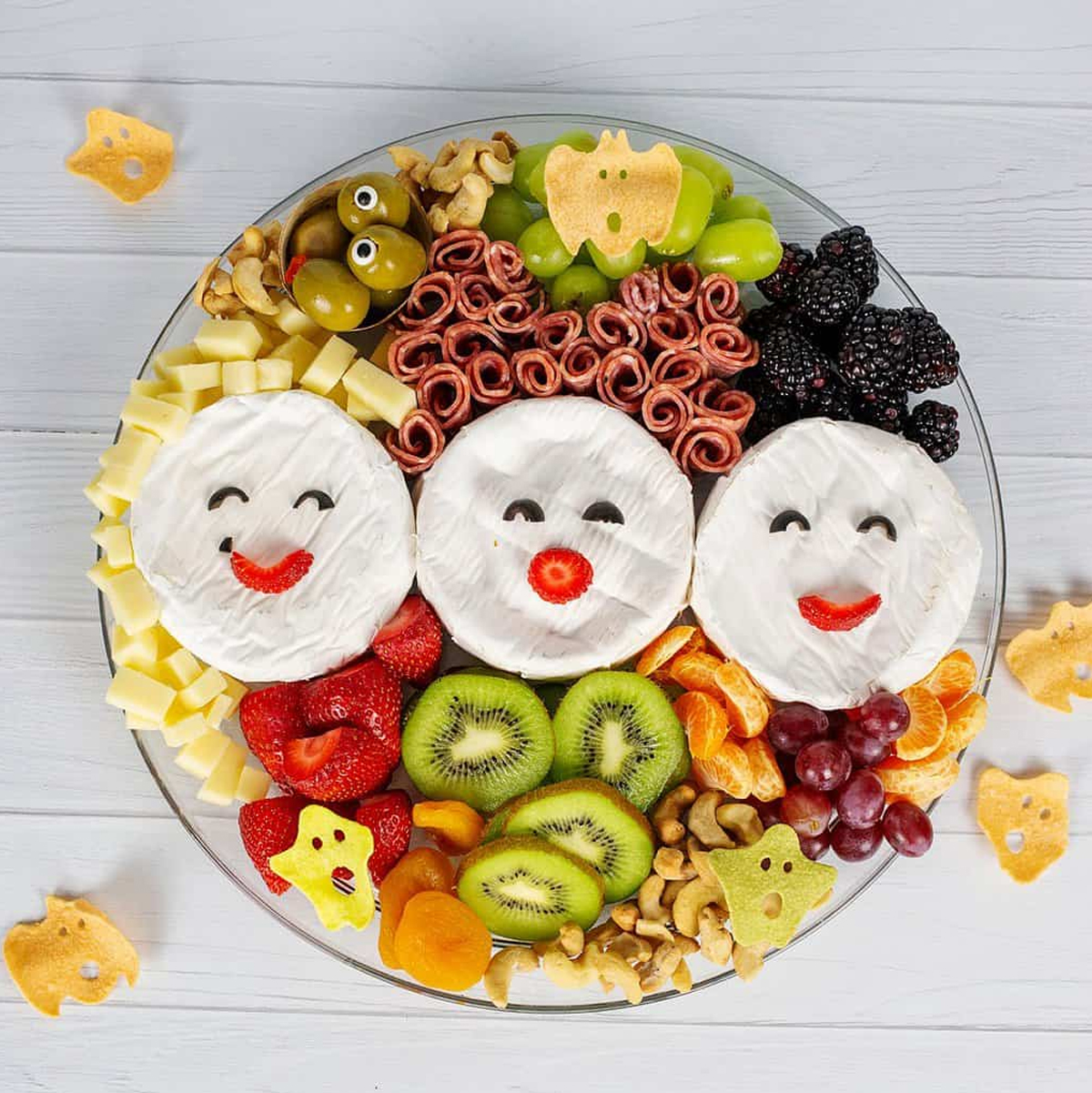 Salami, cheese, grapes, olives, berries, grapes, and kiwi are displayed on Big Family Blessings Hocus Pocus board.