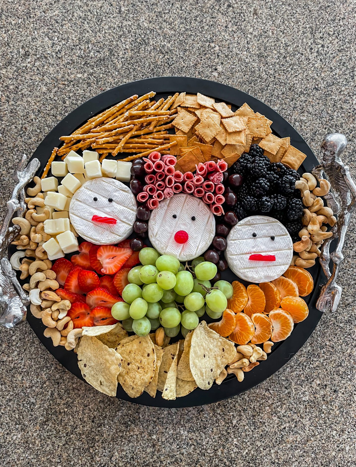 Coming up Roses board presents pretzels, crackers, grapes, meats, cheese, nuts, and berries.
