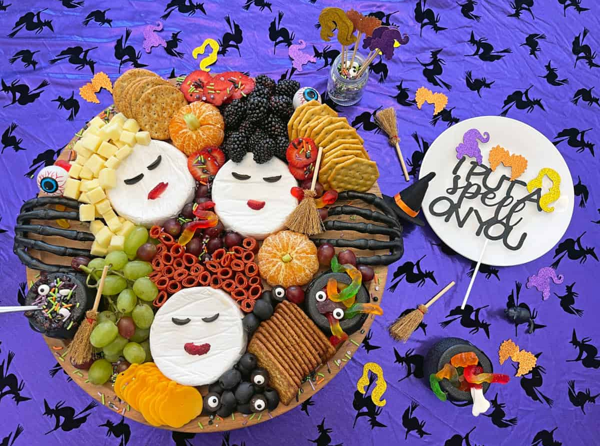 Healthy Family Pro's charcuterie board showcases oranges, berries, grapes, meat, cheese , and gummy worms.