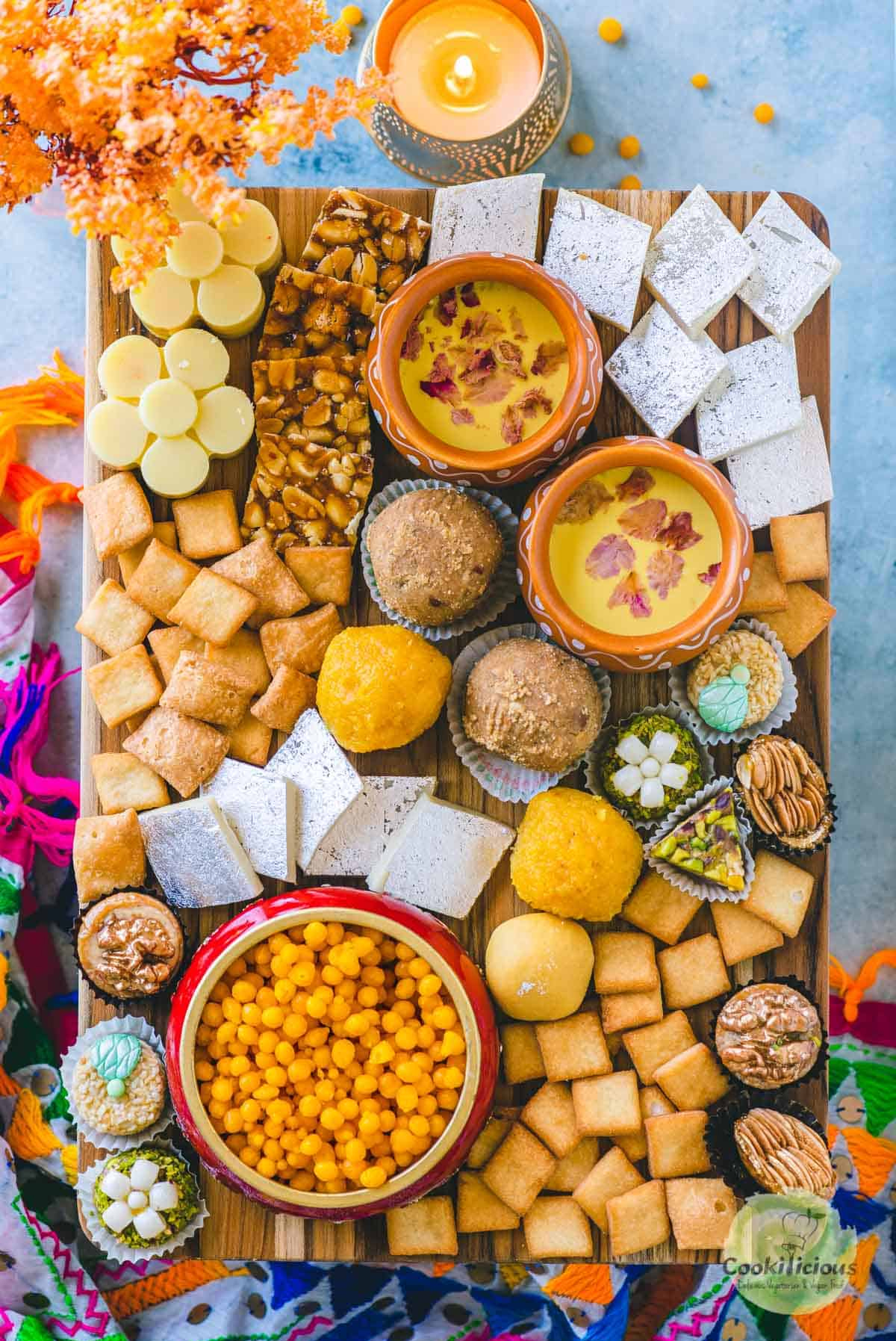 Sweet Boondi, Badam Doodh (Flavored Almond Milk), Shankarpare, Kaju katli, peanuts chikki, mithai flavored chocolates fill Cookilicious's Indian dessert board.