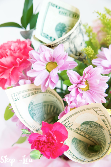 Image shows a money bouquet with real flowers and dollar bills.