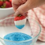 dipping strawberry in blue sanding sugar