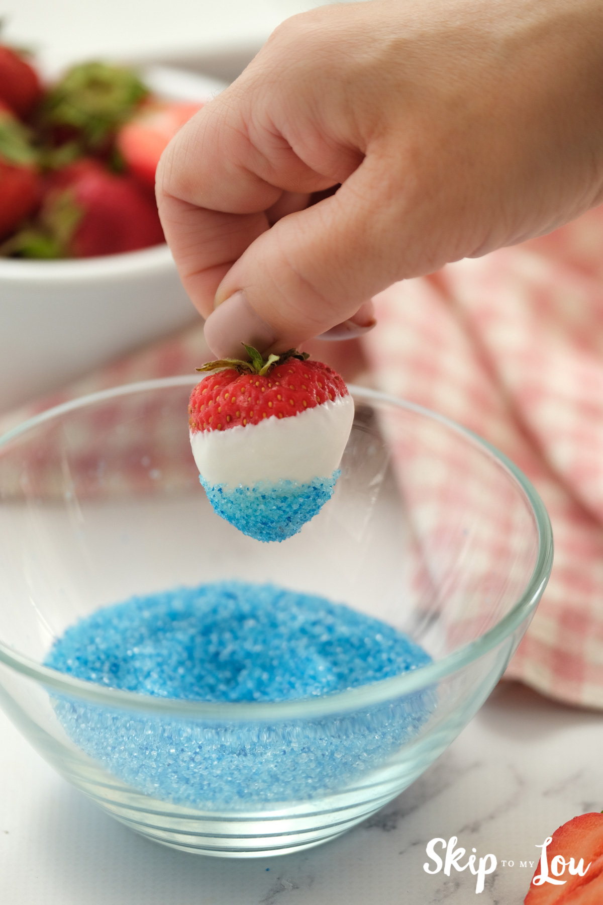 dipping strawberry in blue sanding sugar
