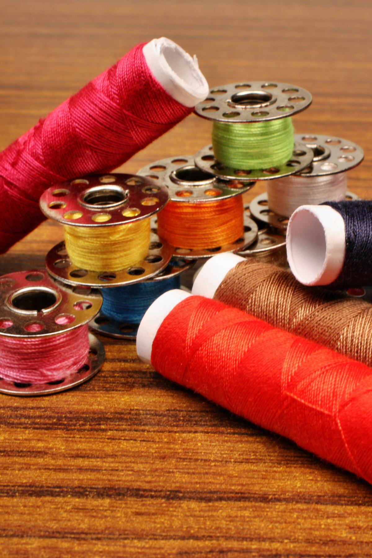 Image shows different types of threads, for machine sewing and hand sewing, in different colors and sizes.