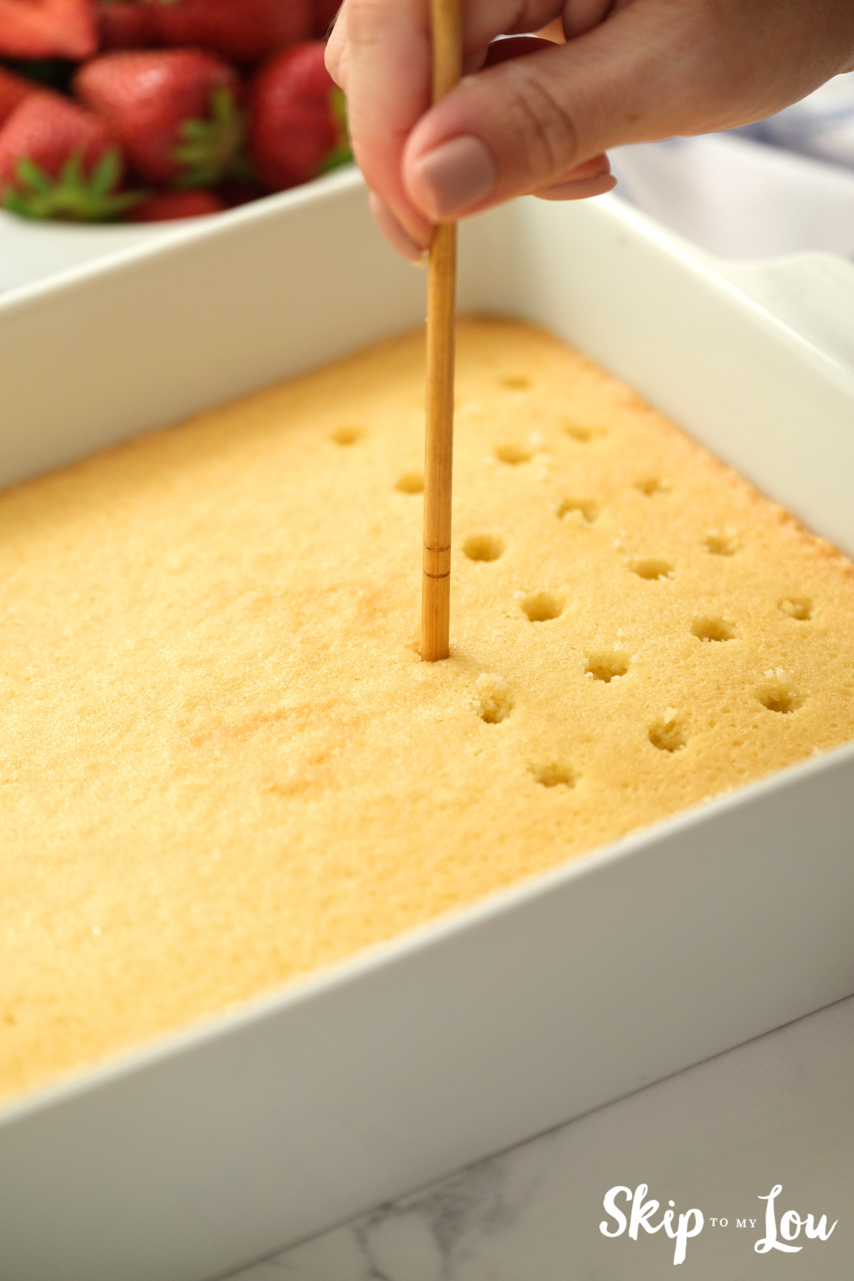 poke cake with wooden spoon