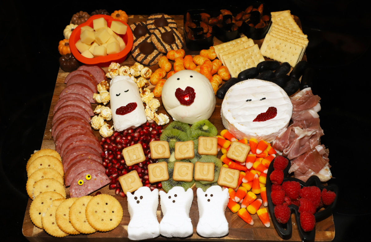 A variety of cheese, meats, fruit, candy, crackers, and cookies fill 4 the Love of Food Blog's Hocus Pocus Halloween board.