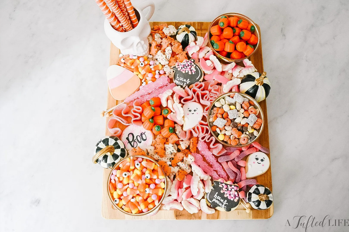 A Tufted Life's Halloween board is filled with cookies, candy corn, gummy worms, and rock candy.