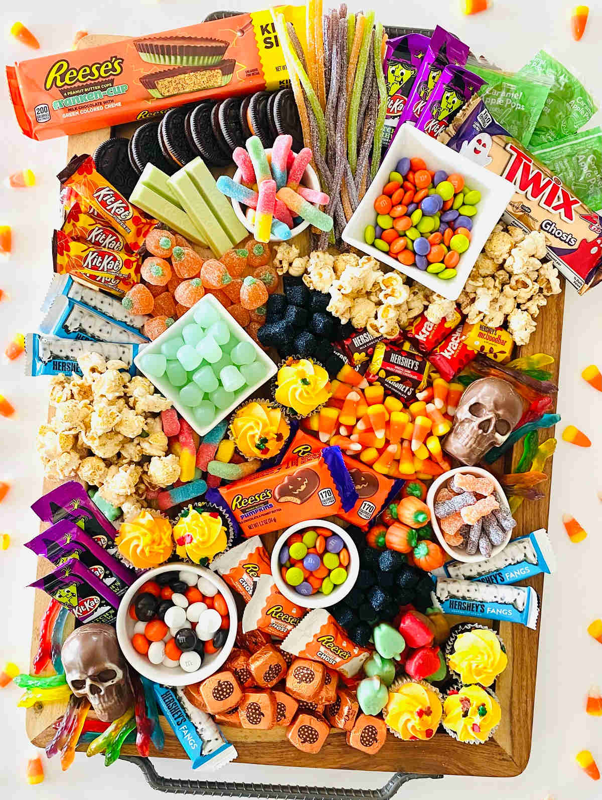 Reese's peanut butter cup pumpkins, candy corn, chocolate skulls, some caramel corn, and cupcakes fill Aubrey's Kitchen charcuterie board.