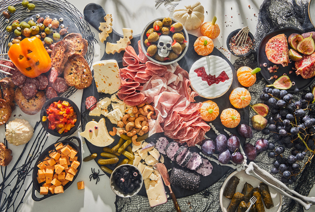 DeLallo's Halloween Charcuterie Board is full of nuts, cheese, meats, olives, and grapes.