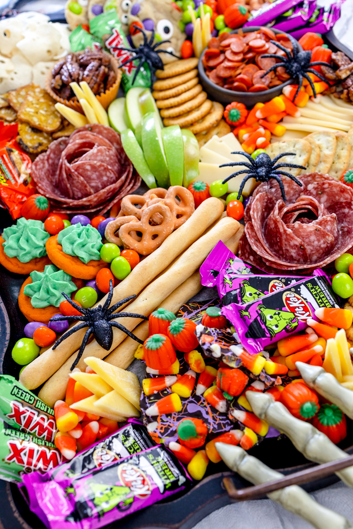 Devour Dinner's Halloween Charcuterie board is filled with cookies, candy, crackers, cheese, and fruit.