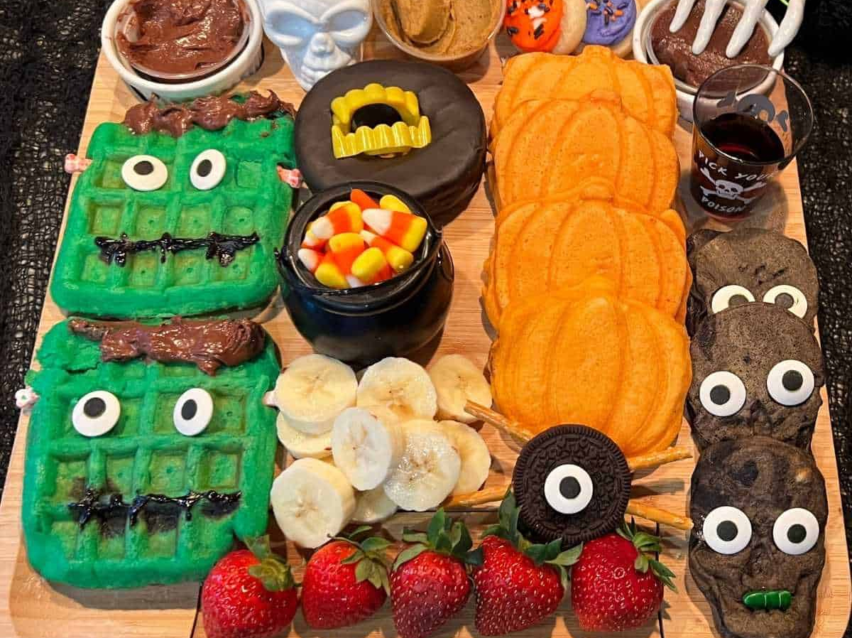 Frankenstein waffles, pumpkin waffles, bananas, cookies, and candy corn fills Dine Dream Discovers Halloween charcuterie board.