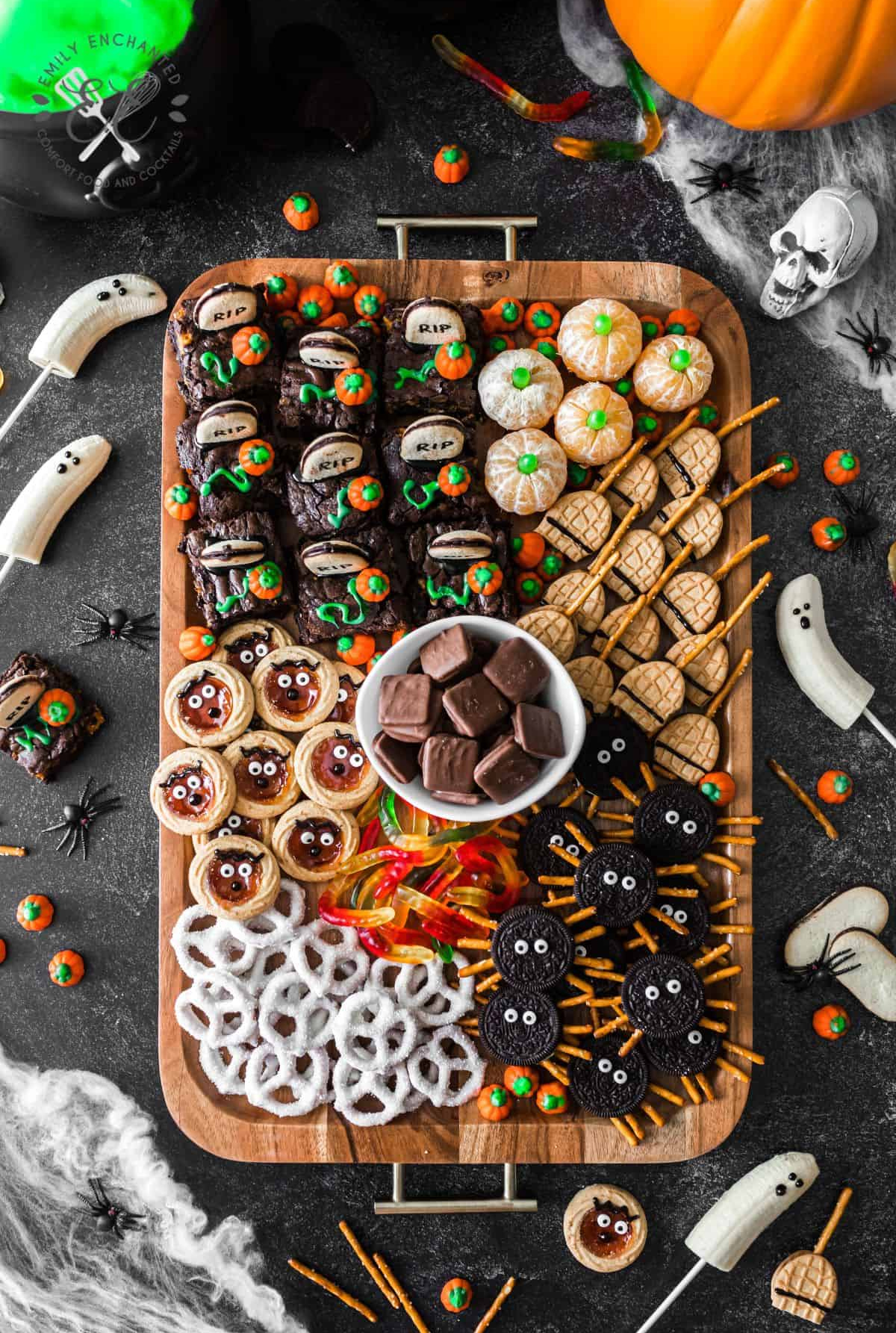 Emily Enchanteds Halloween Charcuterie Board includes brownies, cookies, pumpkin clementine's, pretizels, and candy.