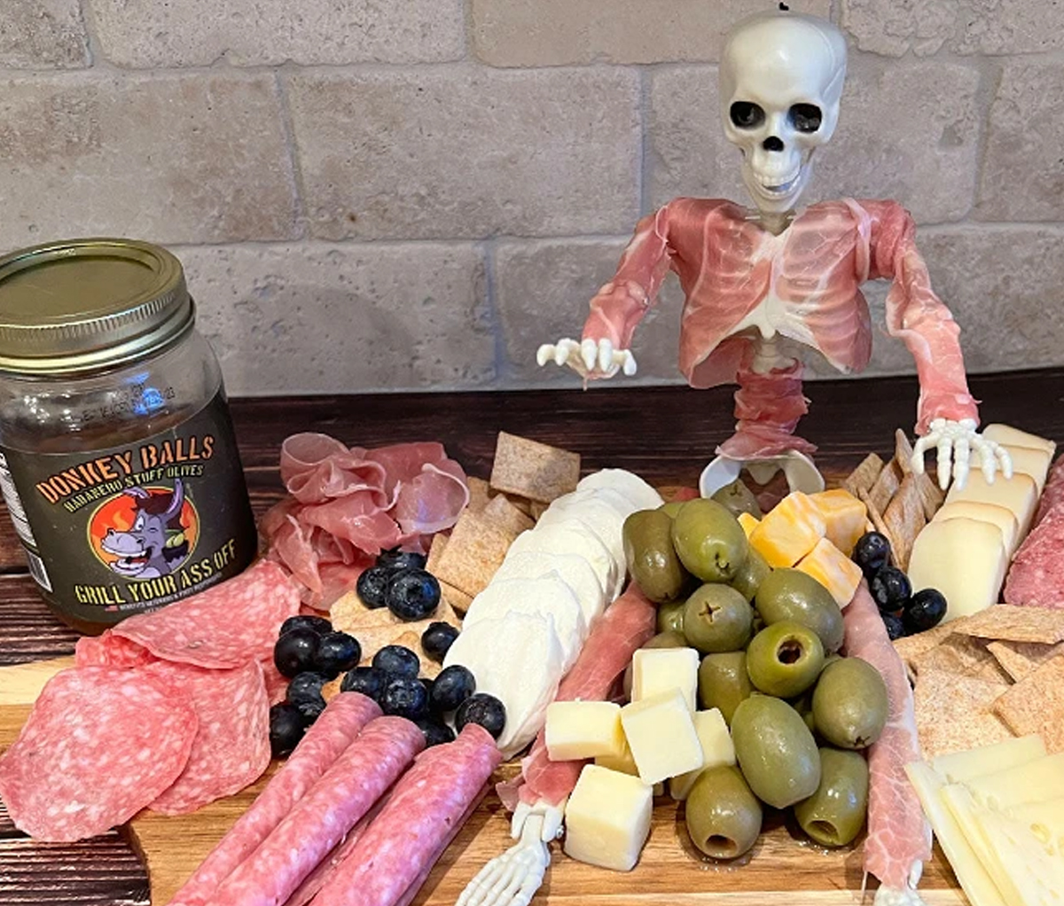 Grill Your Ass Off's Halloween Board showcases meats, cheese, olives, and crackers.