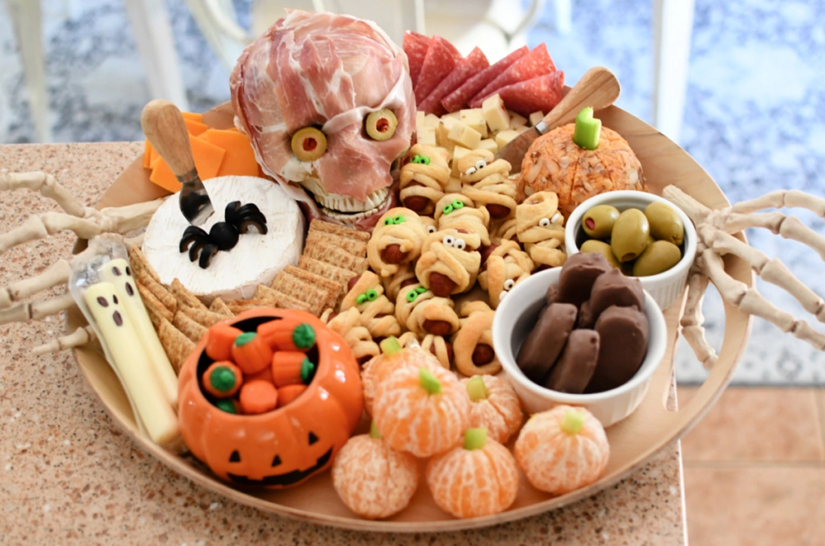 Hip2Save's Board is complete with cheese, meats, candy, olives, fruit, and candy.