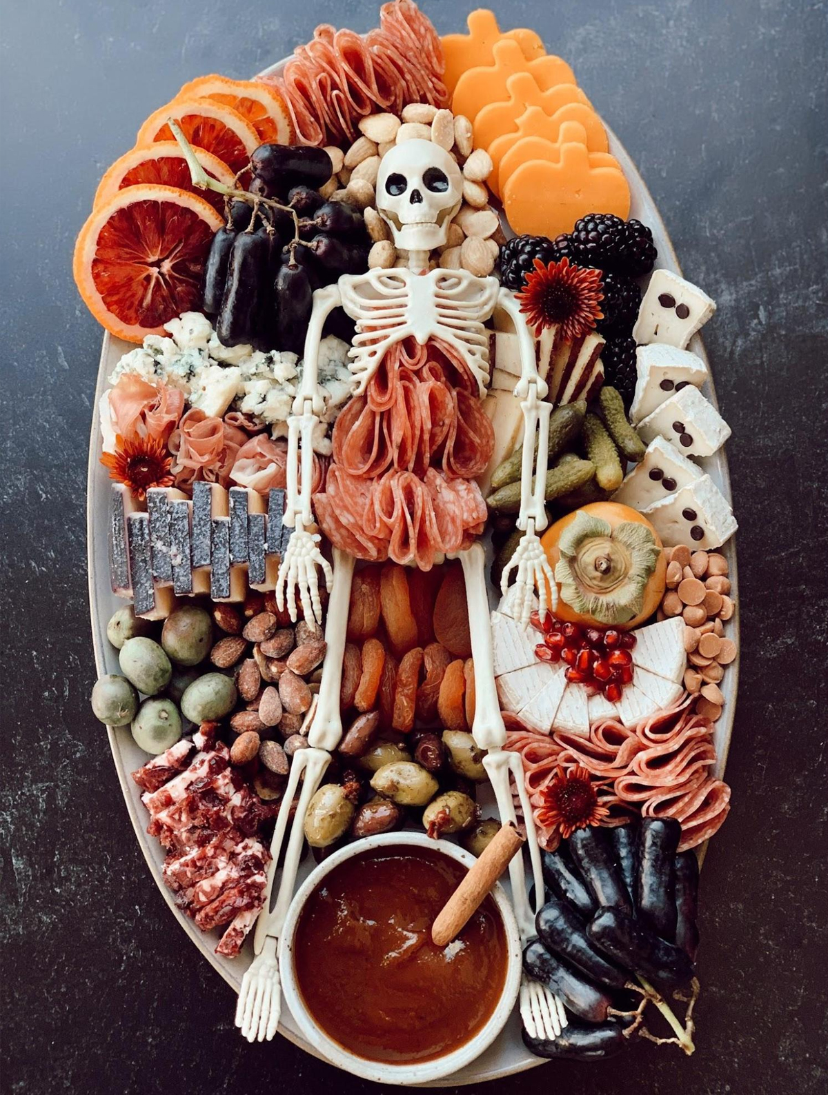 Meats, cheese, pickles, and seasonal fruit fill Melissa's Healthy Kitchen Skeleton Charcuterie Board.