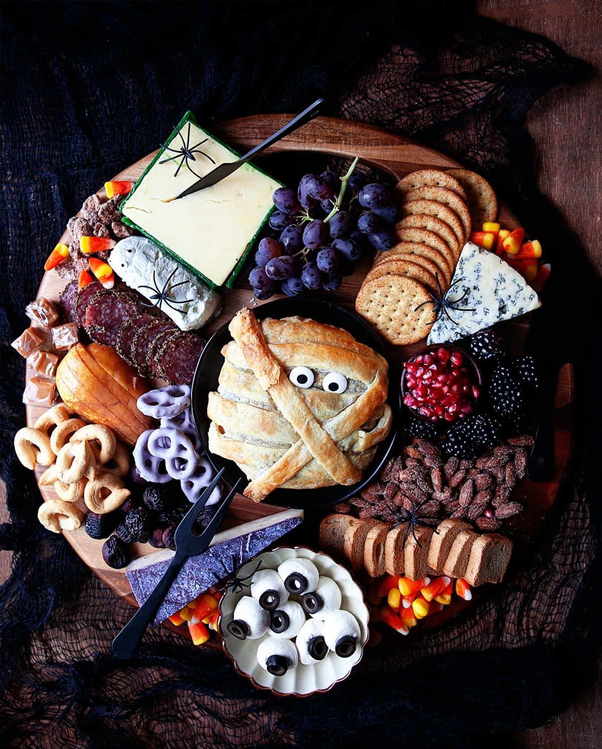 Noshing with the Nolands board includes a mummy baked brie, crackers, pretzels, grapes, and candy corn.