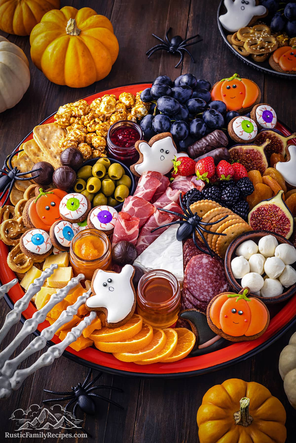 Rustic Family Recipes board is complete with eyeball cookies, olives, meat, crackers, cheese, and fruit.