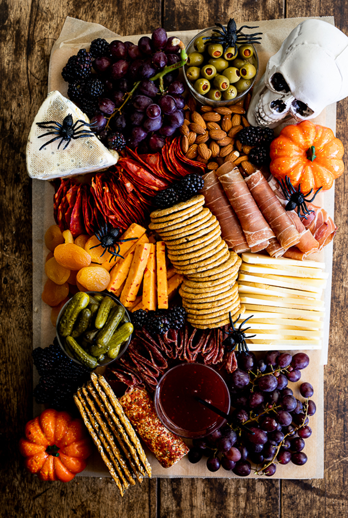 Fruit, cheese, meats, pickles, crackers, and olives fill Simply Delicious Food's Halloween charcuterie board.