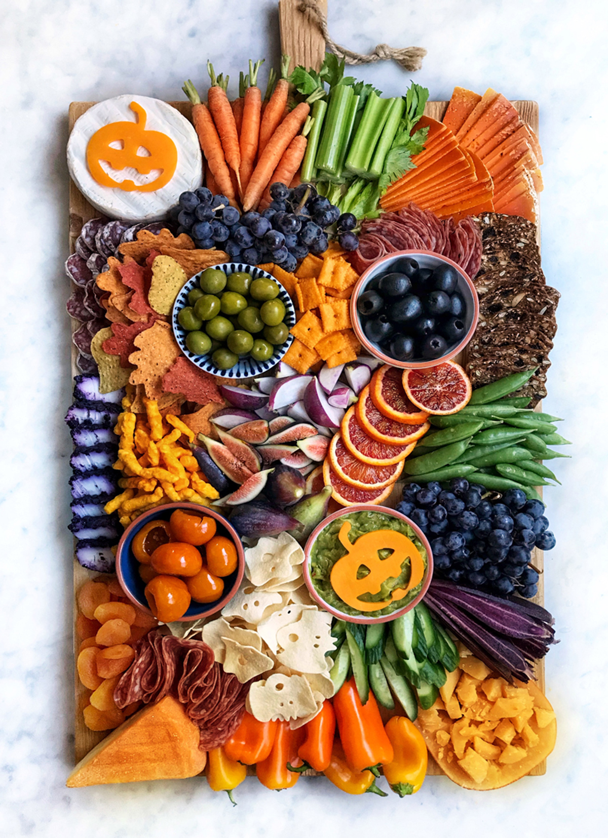 The Delicious LIfe includes oranges, olives, cheese, crackers, veggies, and meat on their Halloween Charcuterie board.