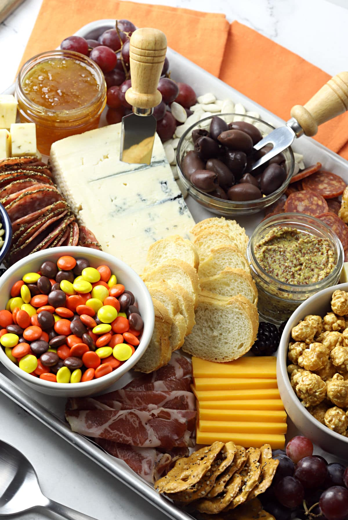 The Toasty Kitchen Halloween Board is filled with olives, grapes, meats, cheese, and crackers.
