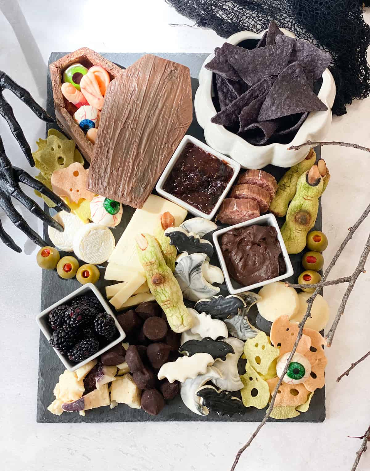 Chips, cheeses, olives, and chocolate fill This Vivacious Life's Halloween board.