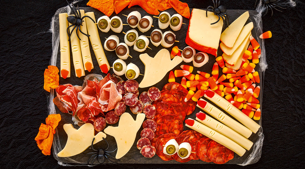 Cheese, meats, and candy corn fill Wisconsin Cheese Halloween board.