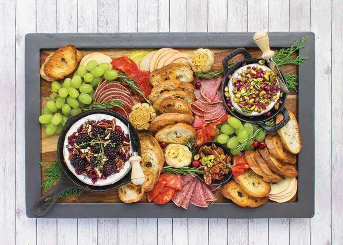 Edit Seven's Board is full of brie, berries, bread, meats, and nuts.