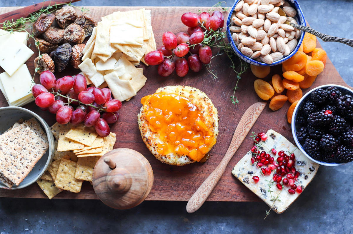 The Golden Barrel showcases berries, dried fruits, nuts, grapes, and cheese on their cheese board.